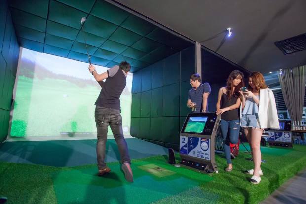 At left, a golfer hits into a screen at one of the more than 5,000 facilities in South Korea with Golfzon simulator
